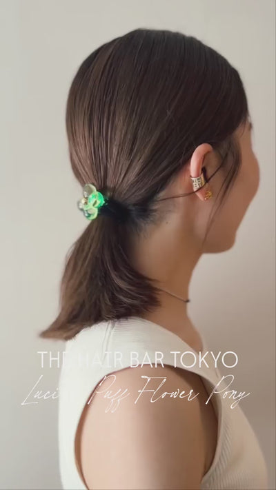 陽光を宿す、ルーサイトの花。

春の訪れとともに、髪に添えるのは「光」そのものです。
生命の瑞々しさを閉じ込めた、彫刻のように美しいフラワーモチーフのヘアゴム。

ガラスよりも軽やかに、クリスタルよりも柔らかな光を放つルーサイト。
計算し尽くされた立体的なフォルムは、角度を変えるたびにドラマティックな陰影を描き出します。

Lucite Puff Flower Pony
本日より全国のショップならびに
オンラインストアにて発売

▶︎インスタハイライトより、デジタルカタログVol-2をご覧ください。

───────────────

#thbt #thehairbartokyo
#ヘアアクセサリー #ヘアアクセ
#フラワー